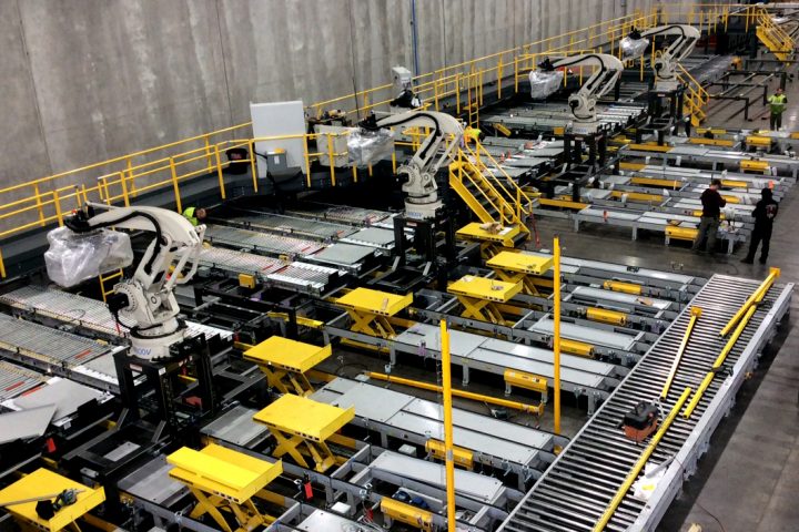 The image shows a huge room with machines and a conveyer belt
