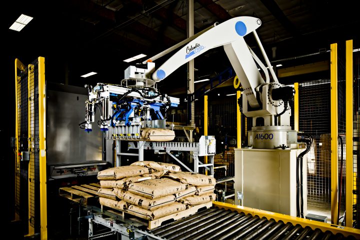 A Columbia Okura robotic arm is placing bags on the conveyor belt